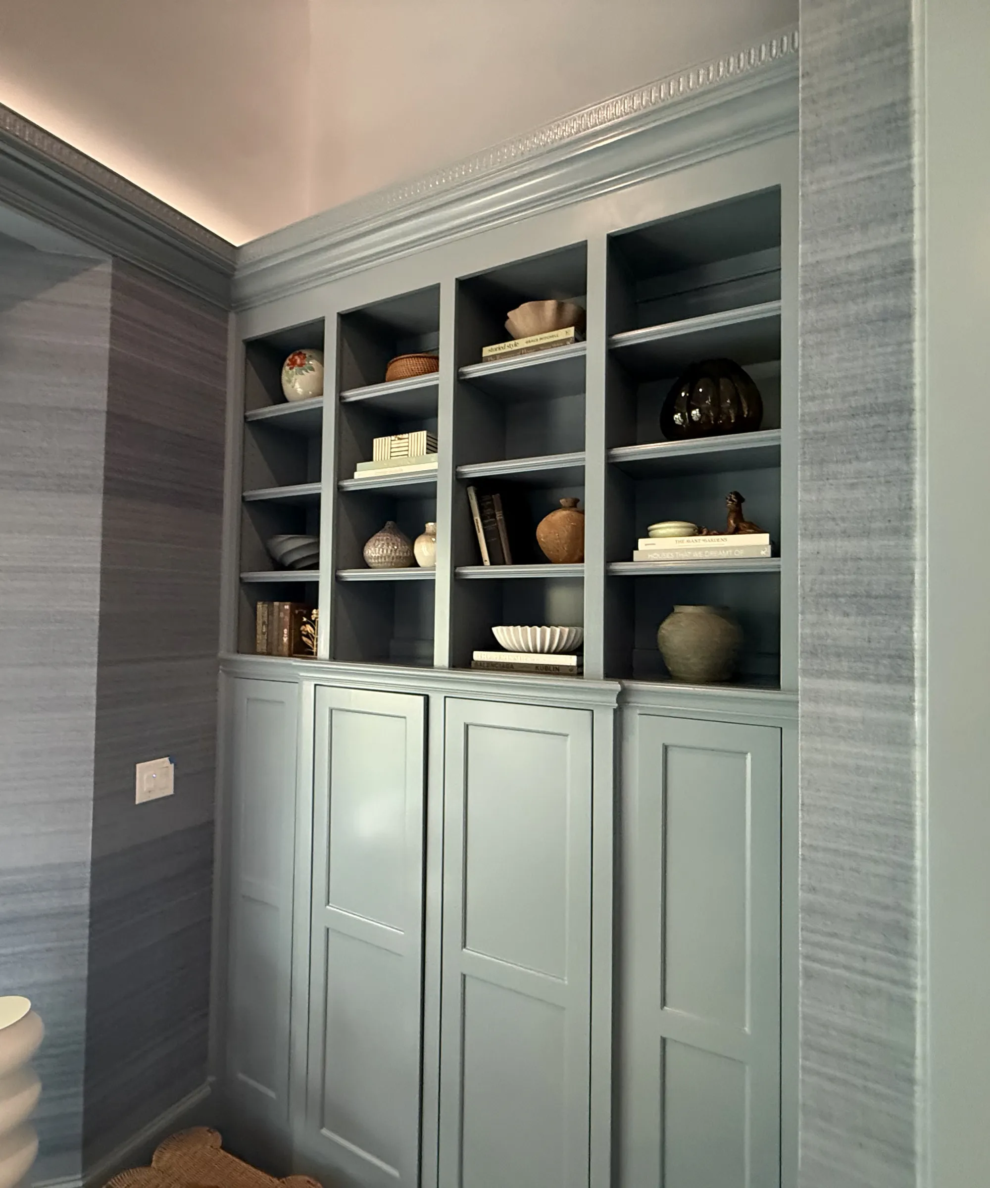Built-in display shelves styled with pottery and books