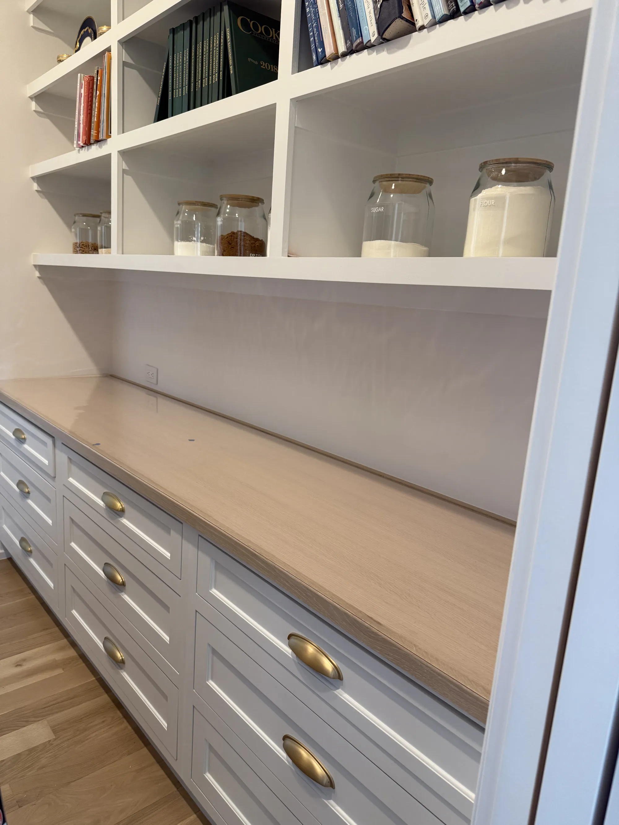 Built-in desk with drawers beneath open pantry shelving